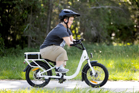 young man with acondroplasia riding a white lightning electric bike side view