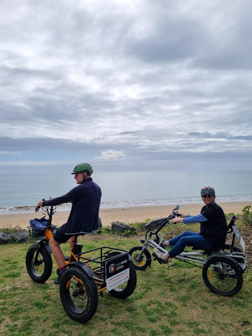 Andrea and Richard riding electric tricycle at the beach