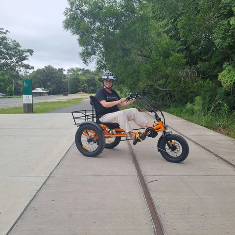 Andrea riding a orange trike