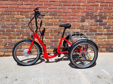 red trike in front of brick wall