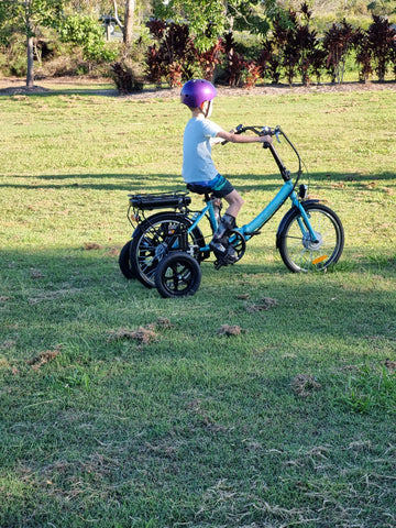 young boy riding electric blue trike