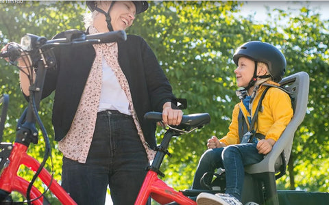 Mum and son smiling at eachother on a ebike