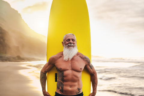 Happy Fit Senior Having Fun Surfing at Sunset