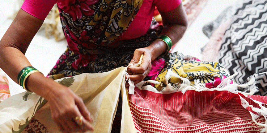 Women manually folding and ironing the final finished silk scarves and shawls ready for shipment