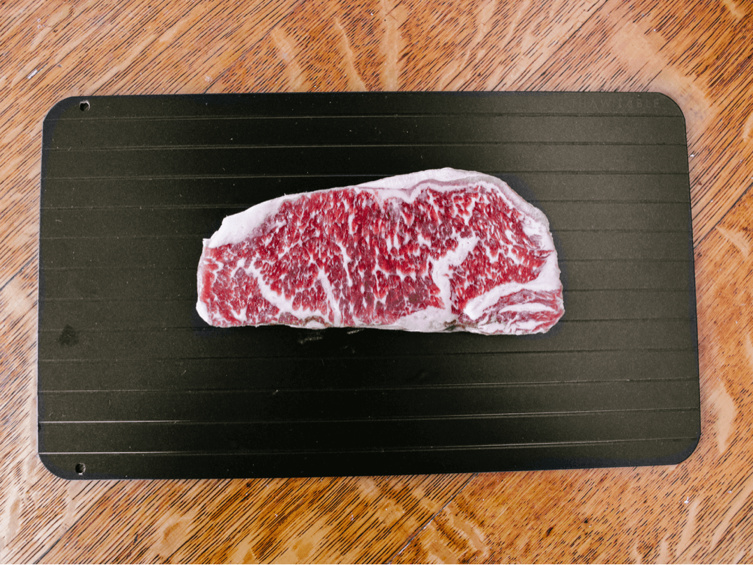 ThawTable - Defrosting Food Reimagined - What's the Best Way to Thaw Wagyu New York Strip Steaks? 12oz Wagyu NY Strip steak from W.Black Wagyu Farm via Crowd Cow sustainable meat delivery box frozen before dinner