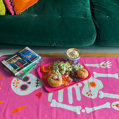 pink-skeleton-table-runner-with-halloween-snack-tray-and-dvds