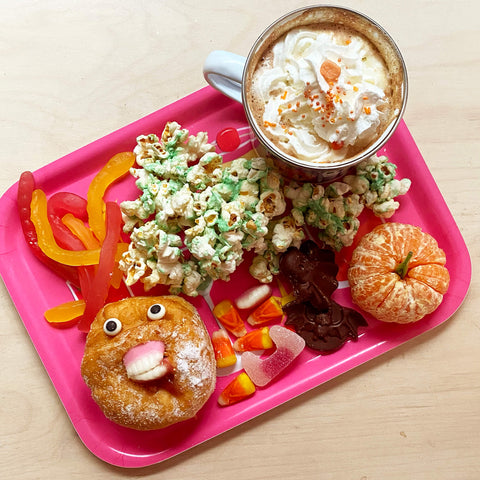 Pink-snack-tray-with-hot-chocolate-donut-popcorn-tangerine-and-sweets