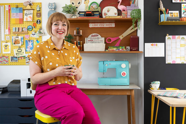 Pippa-sitting-in-front-of-her-sewing-machine-and-desk