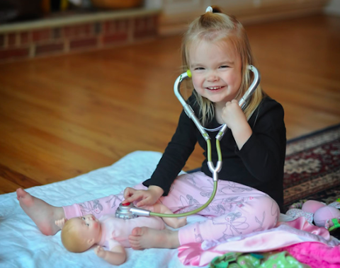little girl playing with doctor toy kit