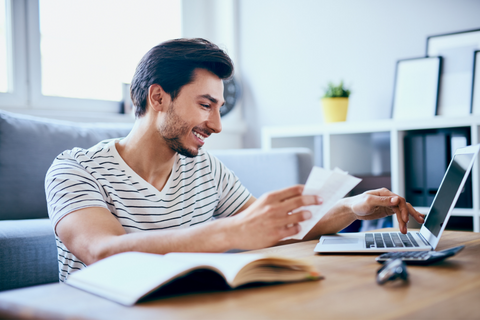 Man smiling while working on his laptop