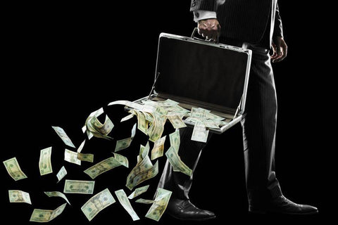 man holding breifcase with money falling out