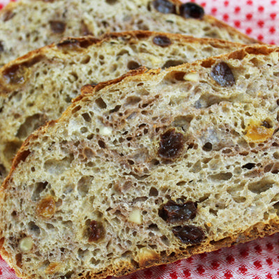 Slices of pecan & raisin bread on a red tablecloth