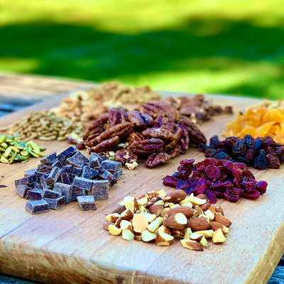 Large cutting board with nuts, dried fruit, chocolate and Fortune Favors candied pecans