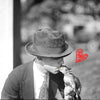 Black and white photo of person feeding a nut to a squirrel