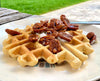 Photo of waffle on a plate topped with pecans