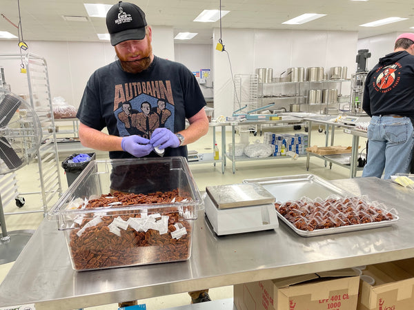 Person packing candied pecans into plastic pouches