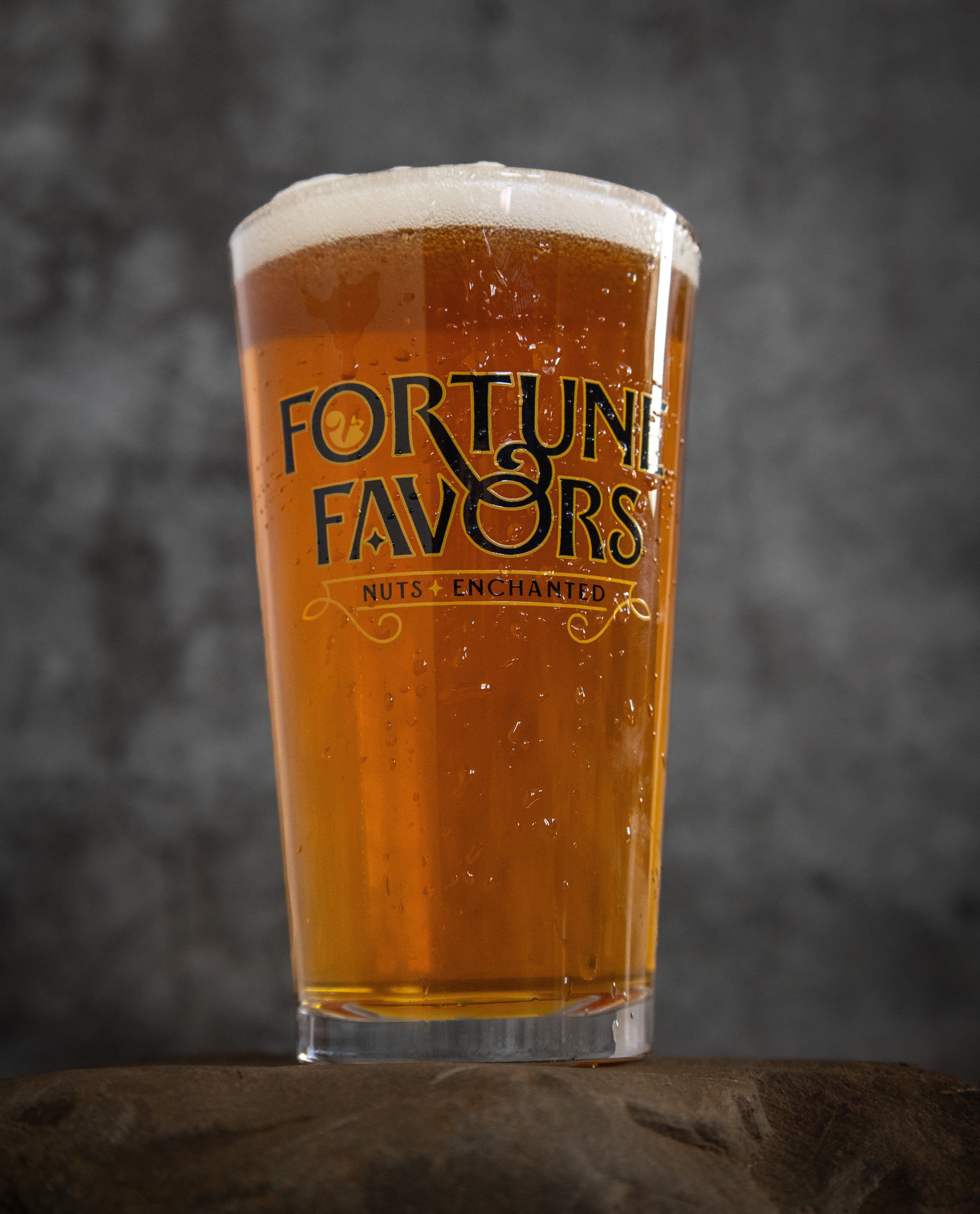 Forrtune Favors branded pint glass full of beer.