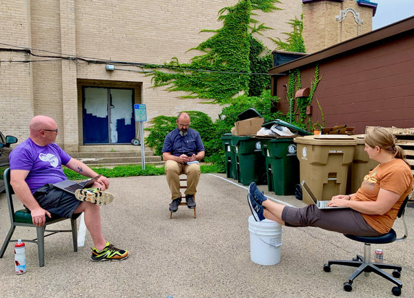 Sam, Eric, and Jess having a leadership meeting outside in a parking lot