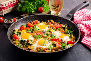 Healthy breakfast of eggs, zucchini, tomatoes, and arugula