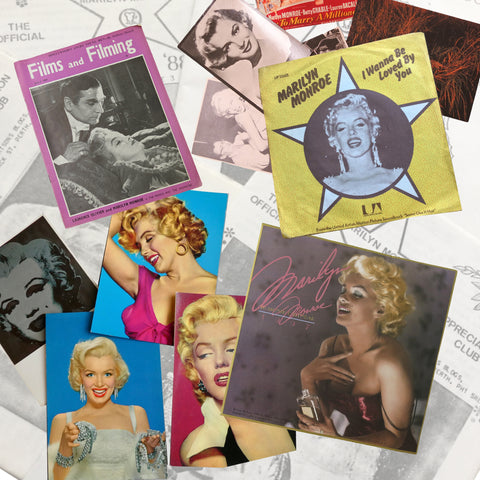 A collection of Marilyn Monroe memorabilia, including magazines, postcards and a record