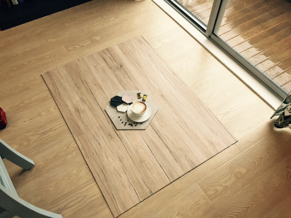 Flatlay set up on a wooden board on the floor with a tray and a coffee