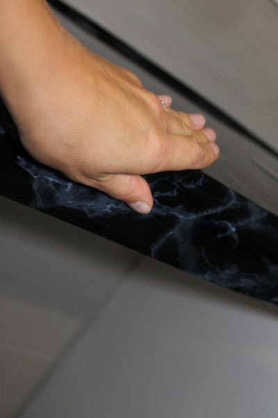 Black marble vinyl wrapped with hand around benchtop edge