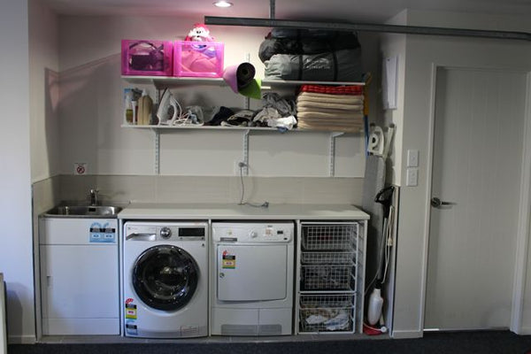 white laundry with storage shelves above