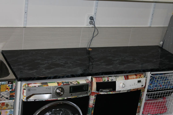 laundry covered with colourful vinyl and black marble bench top