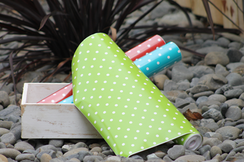 green, blue and red polkadots vinyl rolls in white rustic tray outside