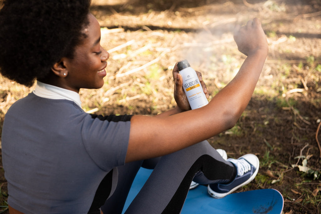 Woman applying Heliocare 360° Invisible Spray