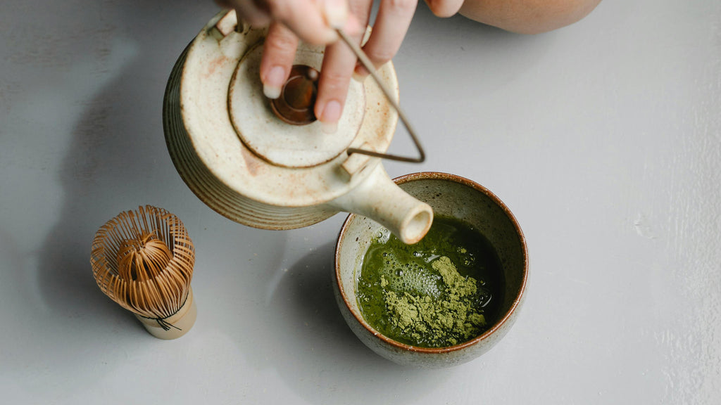 Pouring water into green tea