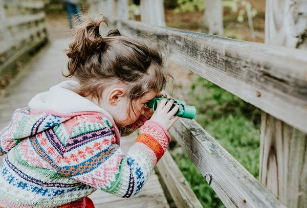 A girl exploring nature with binoculars