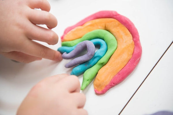A child making a rainbow out of play-dough
