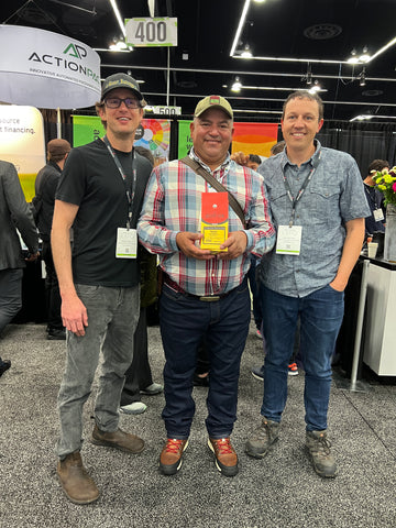 Desert Sun Coffee's owner Zach and head roaster Brian standing with one of our coffee farmers Oscar.