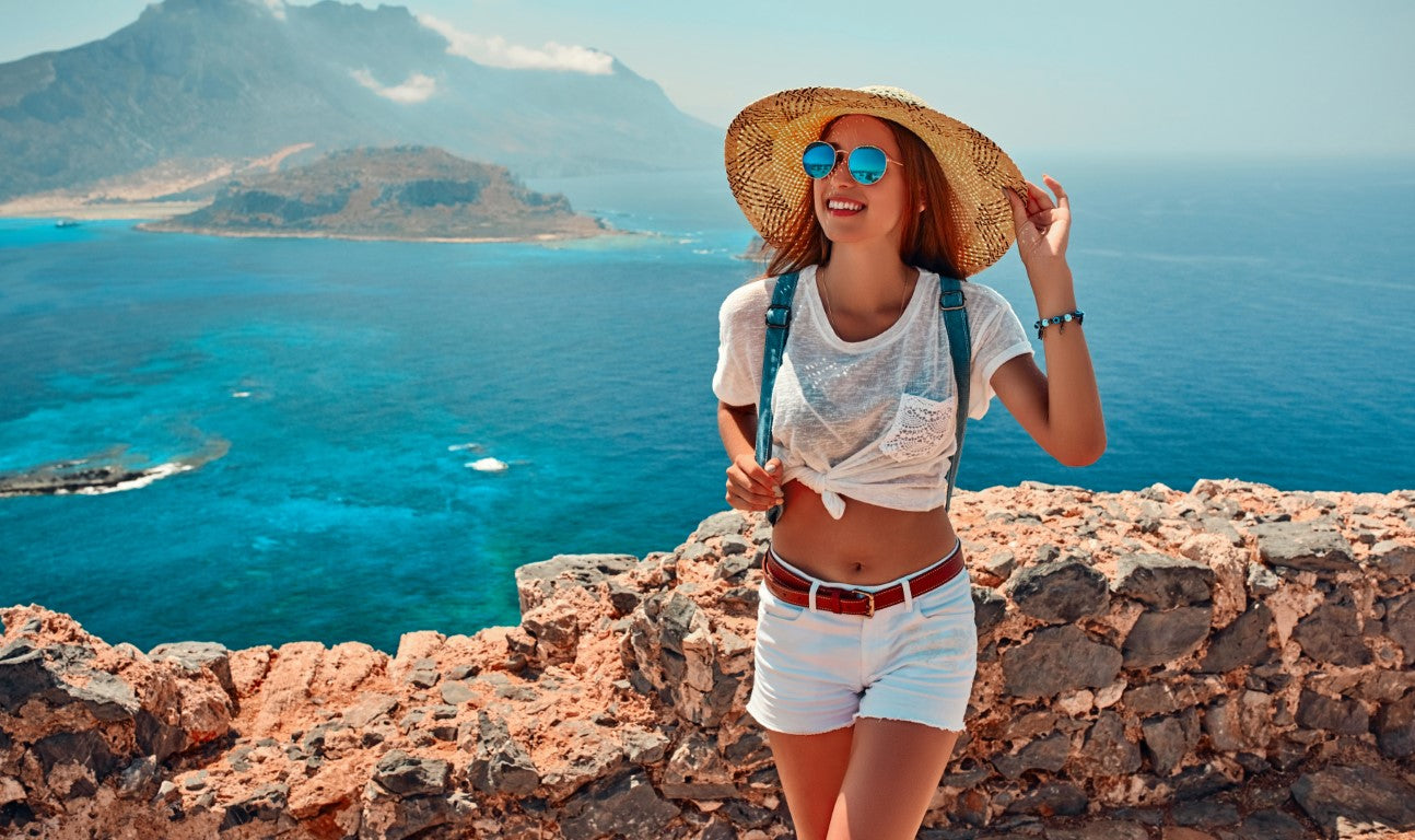 Woman-tourist-happy-wearing-hat-on-rock-sea