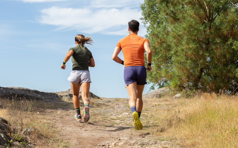 Couple running on trail with Fyke running clothes on.