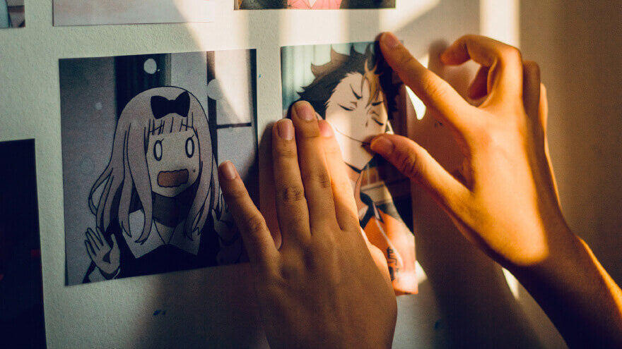 Some anime characters pictures on a bedroom wall