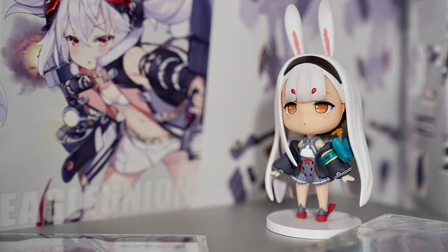 A small anime character figure decoration with a poster behind