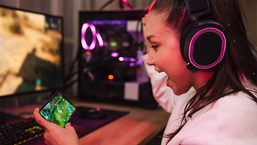A girl with a gamer headset is playing on her smartphone