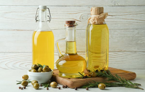 Three bottles of cooking oils on a countertop.