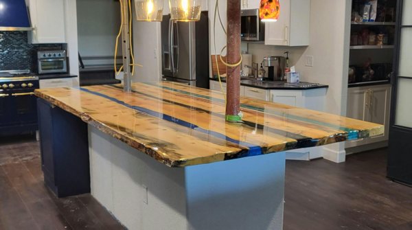 A deep pour wooden epoxy countertop with three river veins of epoxy, each tinted a different color.