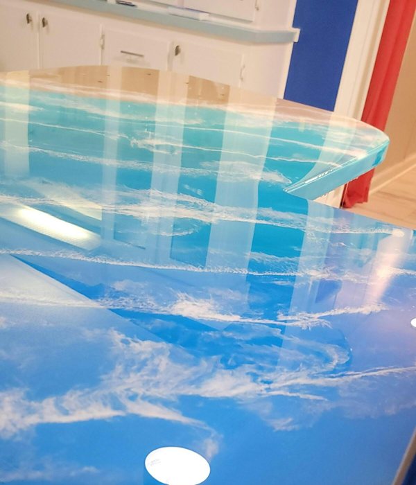 A themed epoxy kitchen countertop with a beach and ocean aesthetic crafted using epoxy pigments.