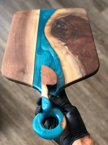 An epoxy charcuterie board with a blue epoxy vein