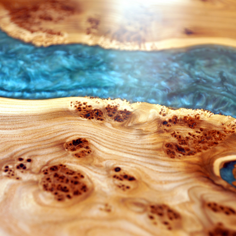 A close-up view of a curving epoxy river table vein