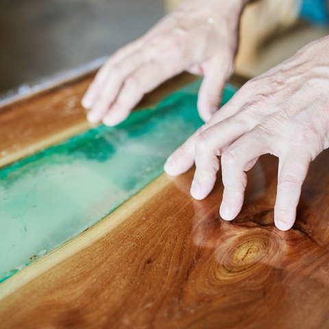 An in-progress river table with a blue-tinted epoxy vein