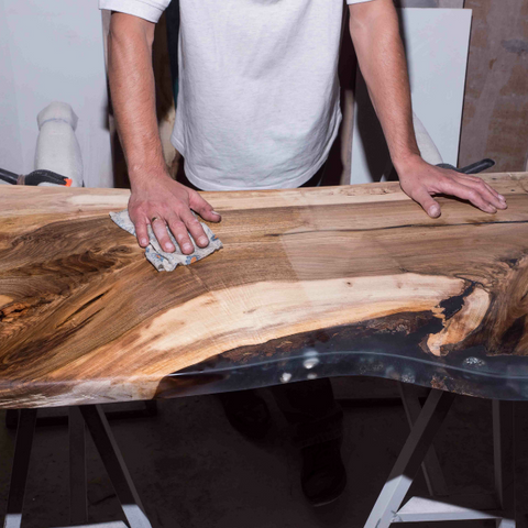 An epoxy river table being cleaned