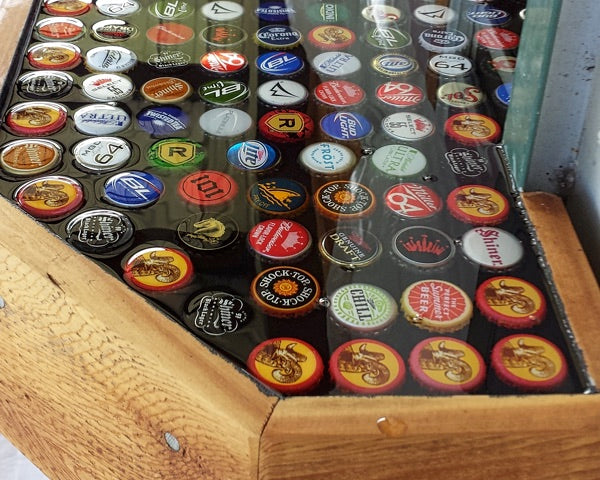 A cured epoxy bottlecap bar top with epoxy seal coats