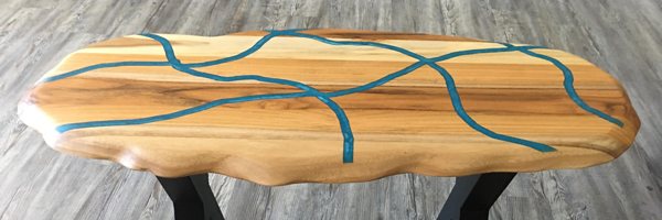 An epoxy table top with several dyed epoxy veins