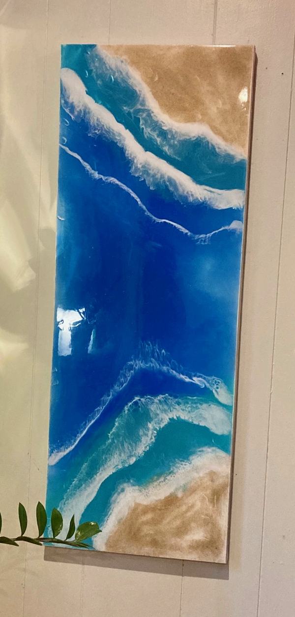 A beach-themed epoxy painting viewed from an angle
