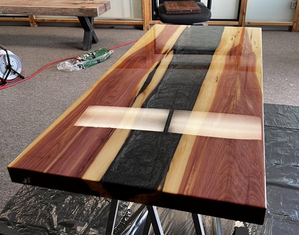 An epoxy river table, made using UltraClear Deep Pour Epoxy and black epoxy pigments.
